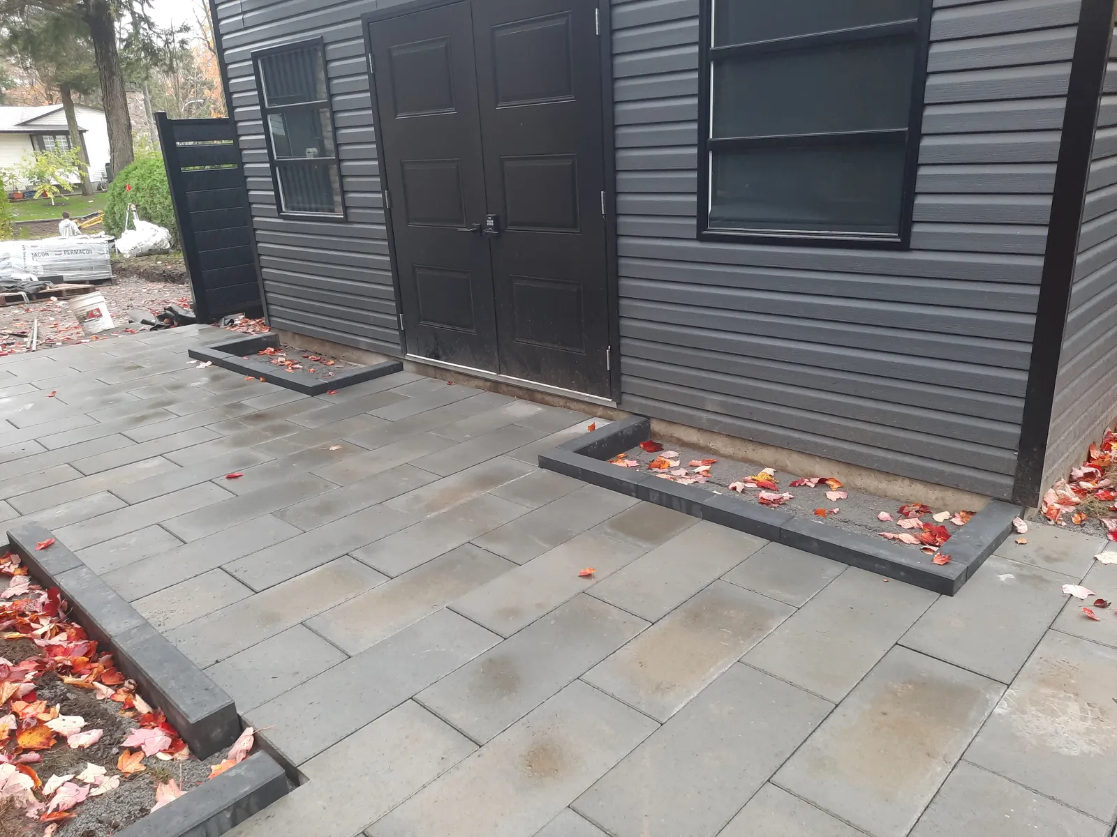 Patio en pavé-uni gris avec bordure foncée